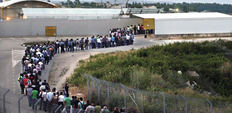 פועלים פלסטינים במעבר חשמונאים / צילום: Reuters