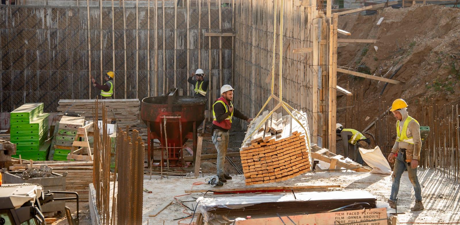 פועלים עובדים באתר בנייה / צילום: Shutterstock פועלים עובדים באתר בנייה / צילום: Shutterstock