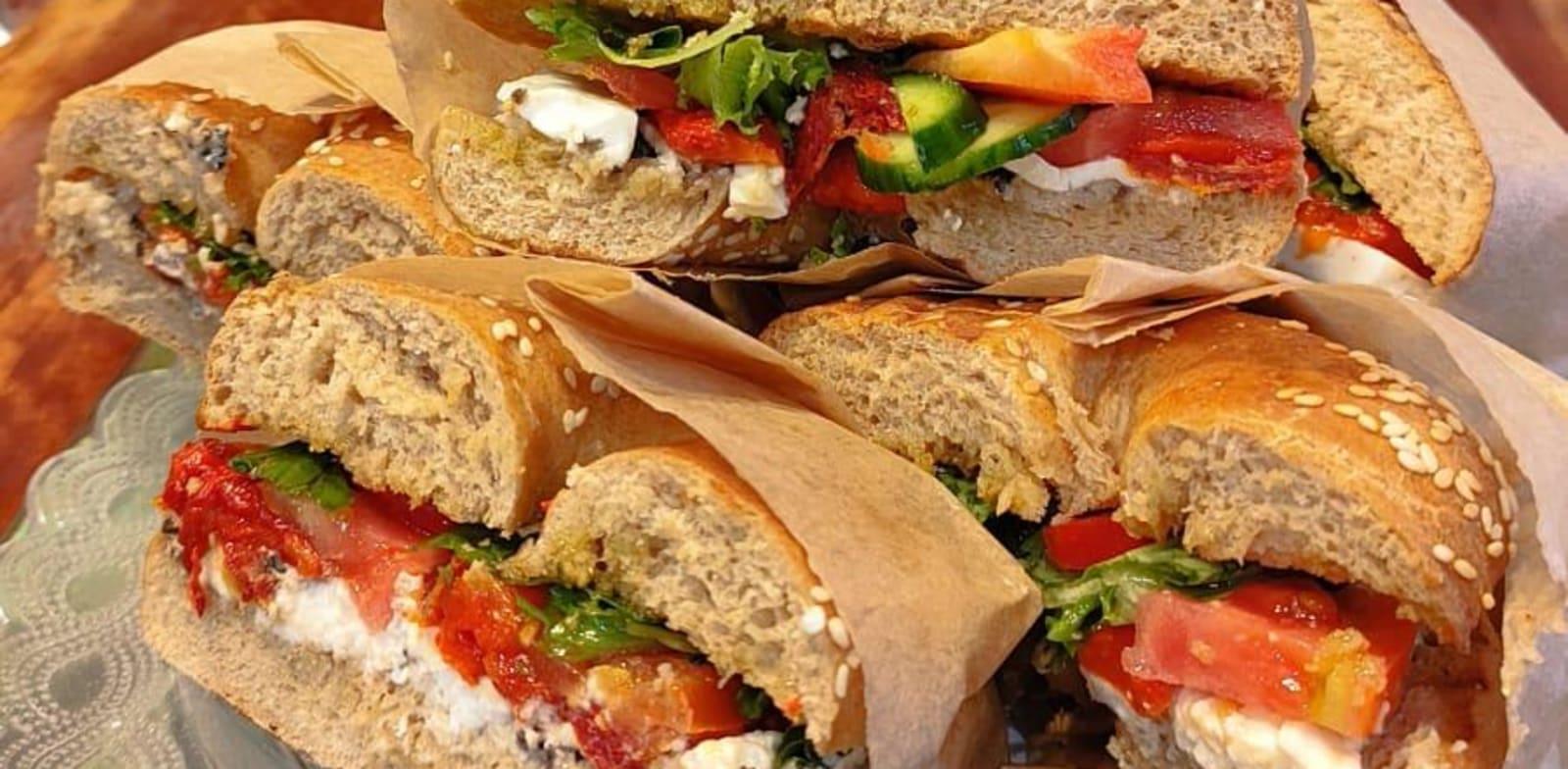 בייגל גבינת עיזים, טפנד זיתים ופסטו בזיליקום במרכולייה / צילום: גיל דותן בייגל גבינת עיזים, טפנד זיתים ופסטו בזיליקום במרכולייה / צילום: גיל דותן